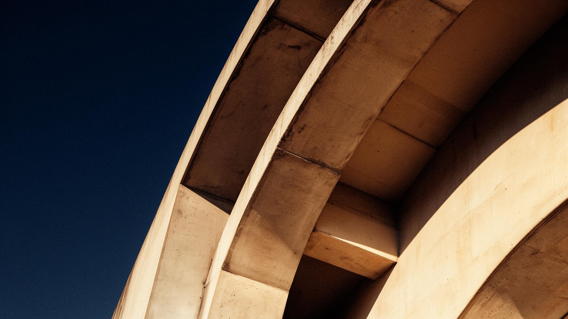 Architectural arches in warm limestone against a deep navy sky